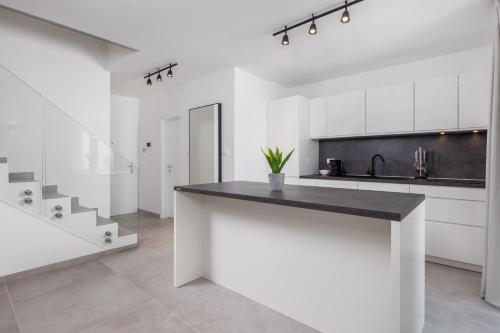 a kitchen with white cabinets and a black counter top at VILLA MAR - LUXURY APARTMENTS with pool and Deluxe apartment with hot tub in Selce, 20 meters from the beach in Selce