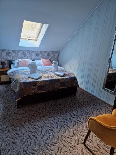 a bedroom with a bed and a chair at Villa Florencia in Bardejov