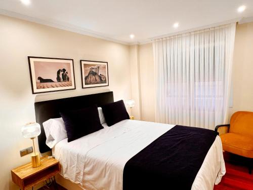 1 dormitorio con 1 cama en blanco y negro y 1 silla en River Deluxe con Garaje gratis, en Bilbao