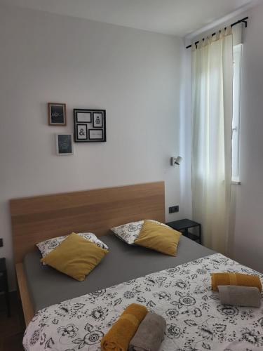 una camera da letto con letto e cuscini gialli di MareAmor Studio Rab a Rab