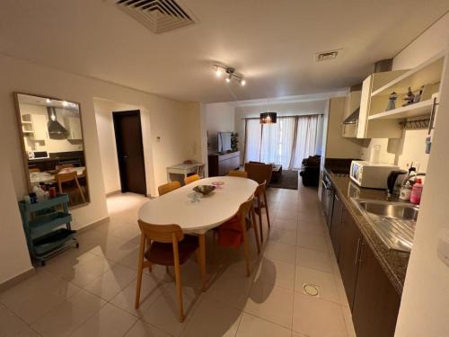 eine Küche und ein Wohnzimmer mit einem Tisch und Stühlen in der Unterkunft Apartment at Samarah Dead Sea Resort in Sowayma