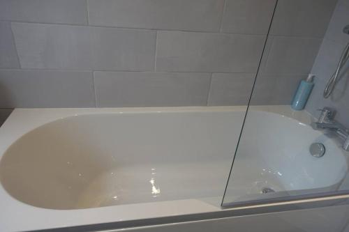 eine weiße Badewanne im Bad mit Waschbecken in der Unterkunft The Reginald in Leeds