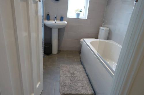 ein Badezimmer mit einer weißen Badewanne und einem Waschbecken in der Unterkunft The Reginald in Leeds