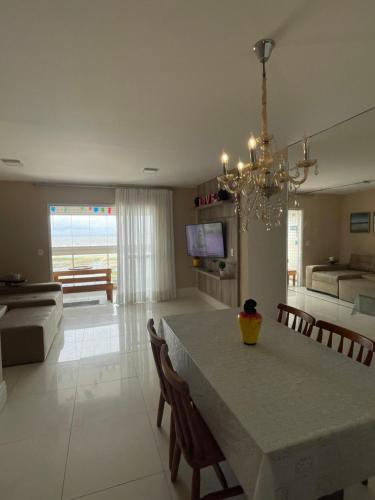 une cuisine et un salon avec une table et des chaises dans l'établissement Aptos atrás da Passarela do Caranguejo, à Aracaju