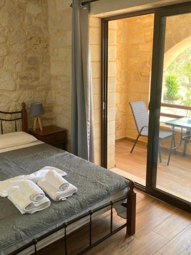 Un dormitorio con una cama y una puerta corrediza de vidrio. en ANEMOS residence, en Exopoli