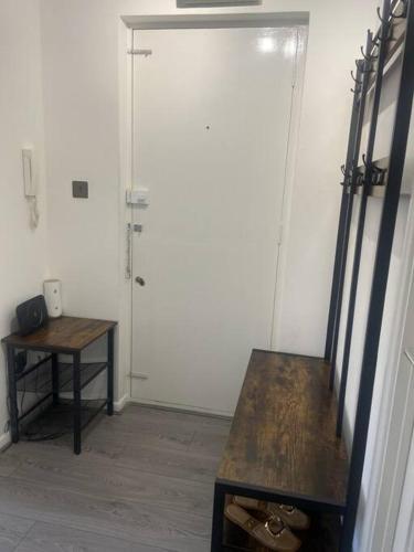 a room with a wooden table and a white door at Grays Serviced Apartment in Stifford