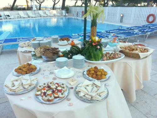 a table with food on it next to a pool at Hotel Bristol in Lignano Sabbiadoro