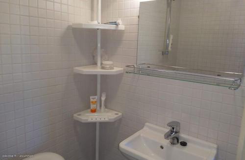 ein Badezimmer mit einem Waschbecken, einem WC und einem Spiegel in der Unterkunft Kotoisa Parkkipaikallinen Kaksio Kangasalan Keskustassa in Kangasala