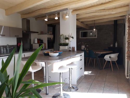 une cuisine avec une table et des tabourets dans une pièce dans l'établissement les Métras, à Ceyzériat