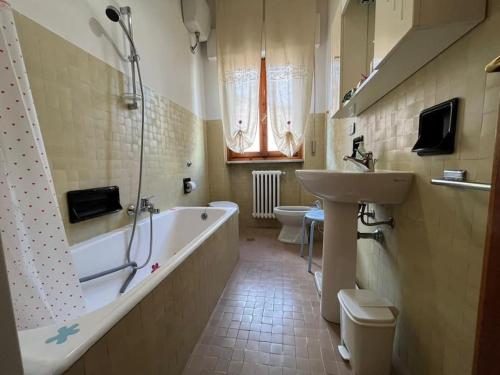 ein Badezimmer mit einer Badewanne, einem Waschbecken und einem WC in der Unterkunft Appartamento “Rosy” in Stia