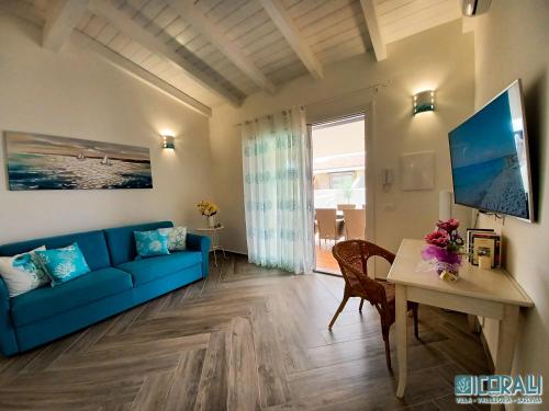 ein Wohnzimmer mit einem blauen Sofa und einem Tisch in der Unterkunft Villa al mare - I CORALLI in Valledoria