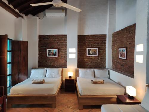 a bedroom with two beds and a ceiling fan at HOTEL NIETO MOMPOX, ubicado en el corazón del centro histórico, frente al rio magdalena en zona de malecón in Mompos