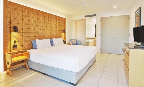 a bedroom with a large white bed and a television at Radisson Blu Resort Fiji in Denarau