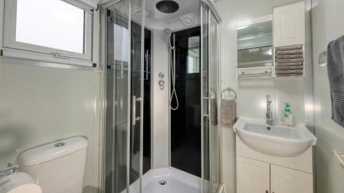 a bathroom with a shower and a toilet and a sink at White Cliffs Self Contained Cabin Accommodation in White Cliffs