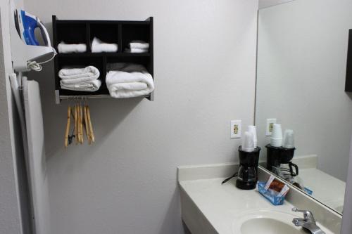 y baño con lavabo, espejo y toallas. en Studio 6 Suites Chattanooga TN Lookout Mtn, en Chattanooga