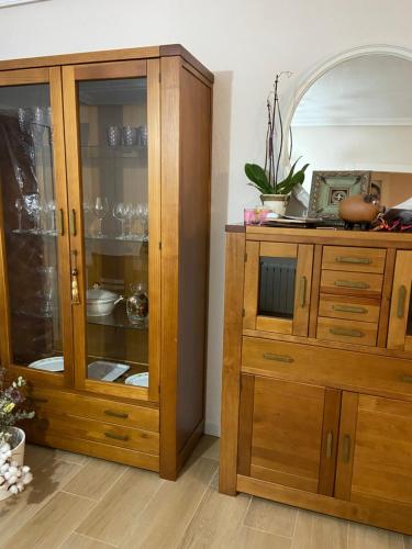 Armario de madera en una habitación con espejo en Apartamentos Plaza del Arco, en Caravaca de la Cruz