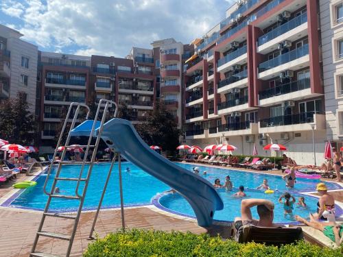 a swimming pool with a slide and people in the water at ADMIRAL PLAZA C 43 Studio Sunny Beach in Sunny Beach