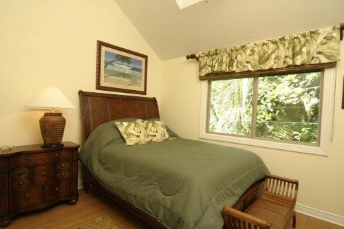 a bedroom with a bed and a window at Beachfront Villa North Shore Oahu in Haleiwa