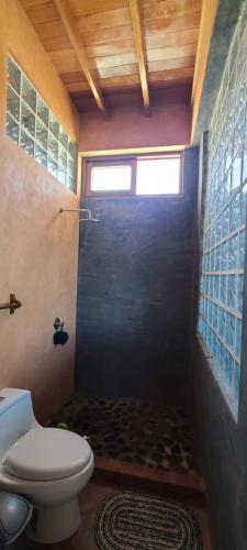 a bathroom with a toilet and a shower with a window at Casa Villa Alive - Vichayito Sur, Los Organos Talara in San Martín