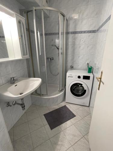 een badkamer met een wasmachine en een wastafel bij Fürstner Haus 
