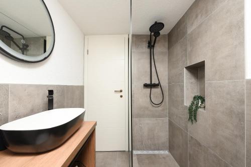 a bathroom with a black tub and a shower at Holiday Stone House - Fumarea in Rtina