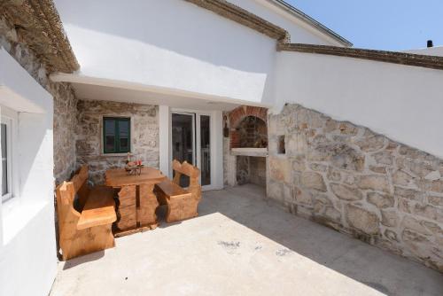 a room with a stone wall and a table and chairs at Holiday Stone House - Fumarea in Rtina