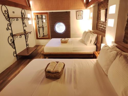 a small room with two beds and a window at HOTEL NIETO MOMPOX, ubicado en el corazón del centro histórico, frente al rio magdalena en zona de malecón in Mompos