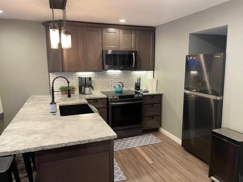 a kitchen with wooden cabinets and a stainless steel refrigerator at Lakefront Luxury Condo with Stunning Views!! in Dillon