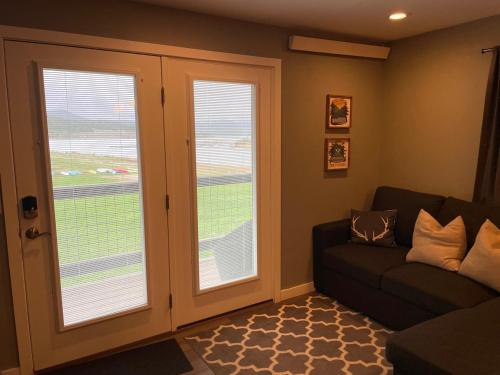 a living room with a couch and two windows at Lakefront Luxury Condo with Stunning Views!! in Dillon
