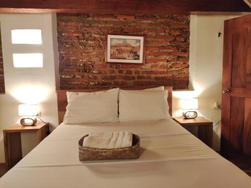 a bedroom with a bed with a brick wall at HOTEL NIETO MOMPOX, ubicado en el corazón del centro histórico, frente al rio magdalena en zona de malecón in Mompos
