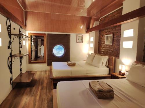 a bedroom with two beds and a window at HOTEL NIETO MOMPOX, ubicado en el corazón del centro histórico, frente al rio magdalena en zona de malecón in Mompos