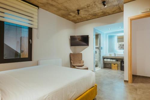 a bedroom with a bed and a television and a bathroom at Anemmaro Villa 1 in Crete in Gournes