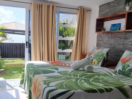 Schlafzimmer mit einem Bett und einem Fenster in der Unterkunft VILLA SUNRISE MOOREA in Papetoai