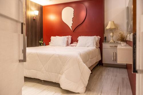 a bedroom with a large bed with a heart headboard at Hotel Cravo e Canela in Campos dos Goytacazes