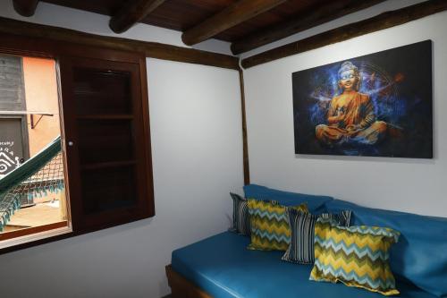 a blue couch in a room with a painting on the wall at Casas Temporada Aldeia Niura Opy in Florianópolis
