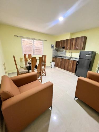 a living room with two couches and a kitchen at Hotel La playa in Santa Cruz de Barahona