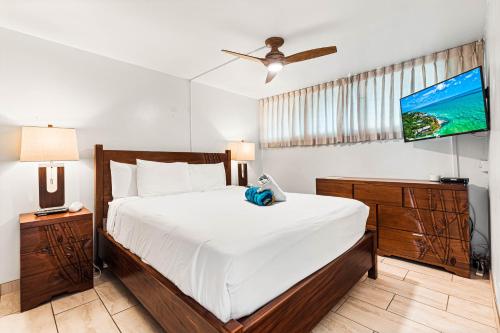 um quarto com uma cama e uma televisão na parede em Maui Parkshore 407 em Wailea