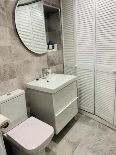 a bathroom with a toilet and a sink and a mirror at Station House in Ballina