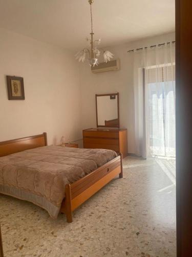 - une chambre avec un lit, une commode et un miroir dans l'établissement Appartamento Peschici, à Peschici
