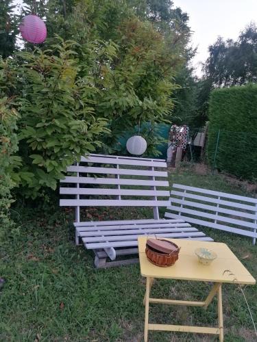 een witte bank en een tafel in het gras bij Chambre au coeur de la Sologne in Romorantin
