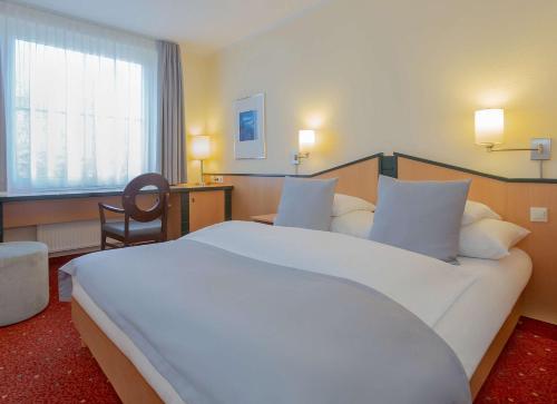 ein großes weißes Bett in einem Hotelzimmer in der Unterkunft Essential by Dorint Remscheid in Remscheid