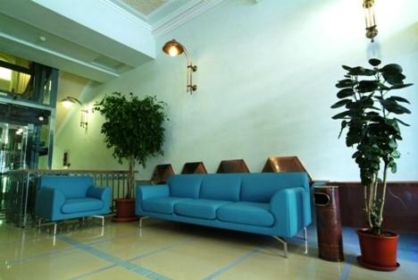 a blue couch and two chairs in a lobby at Hotel Eden in Naples