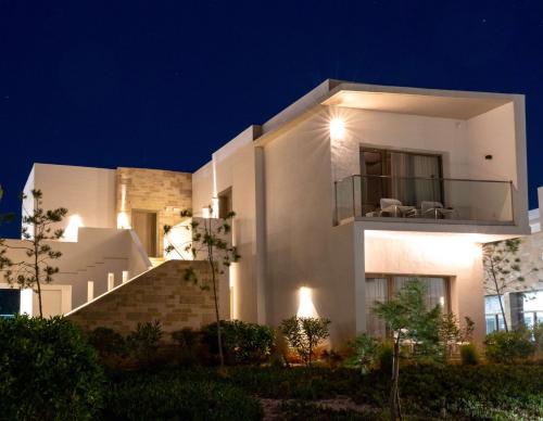 a white house with a balcony at night at Radisson Blu Resort Al Hoceima in Al Hoceïma