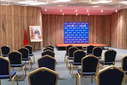 a conference room with chairs and a projection screen at Radisson Blu Resort Al Hoceima in Al Hoceïma