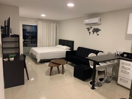 a bedroom with a bed and a desk and a couch at Apartamento JC Santa Cruz Norte in Santa Cruz de la Sierra