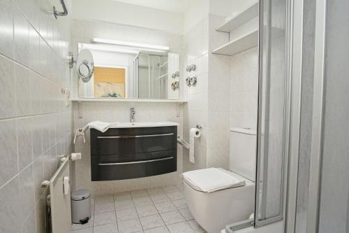 a white bathroom with a toilet and a sink at Apartmentanlage Eldena Ferienwohnung 10 in Lobbe