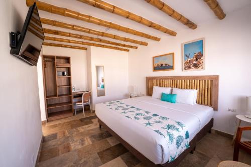 a bedroom with a large bed and a desk at Atoq Paracas Reserva in Paracas