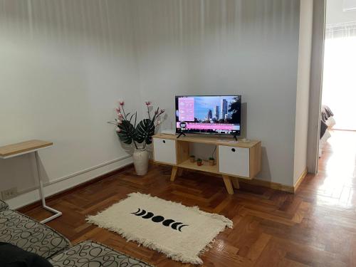 sala de estar con TV de pantalla plana sobre una mesa en Cómodo dos ambientes en Buenos Aires