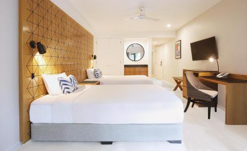 a hotel room with two beds and a desk at Radisson Blu Resort Fiji in Denarau