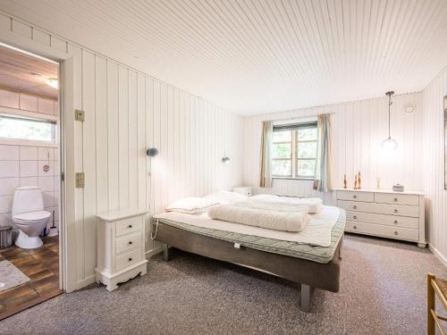 a white bedroom with a bed and a bathroom at Holiday home Blåvand CCXXXVIII in Blåvand